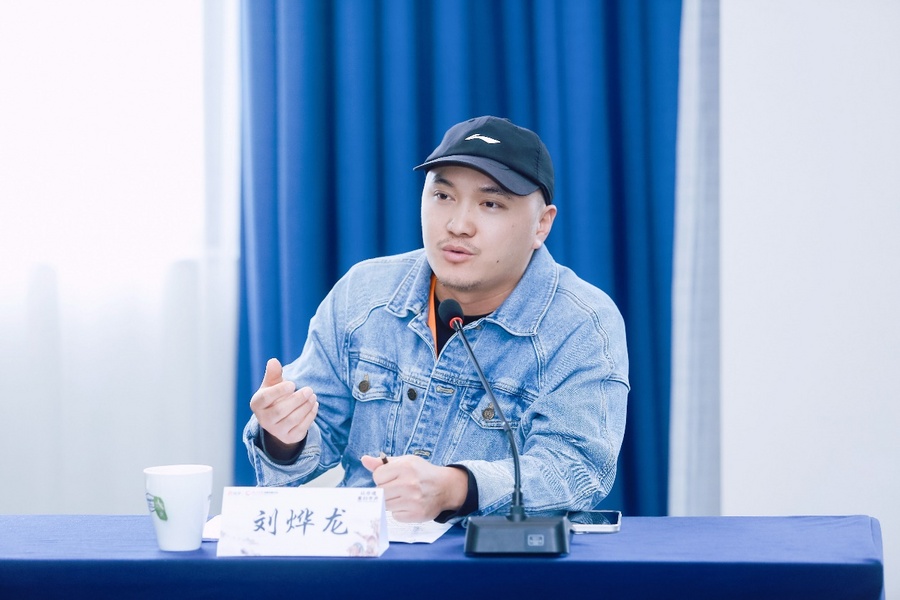 穿着蓝色衣服的男人在桌子前摆拍低可信度描述已自动生成